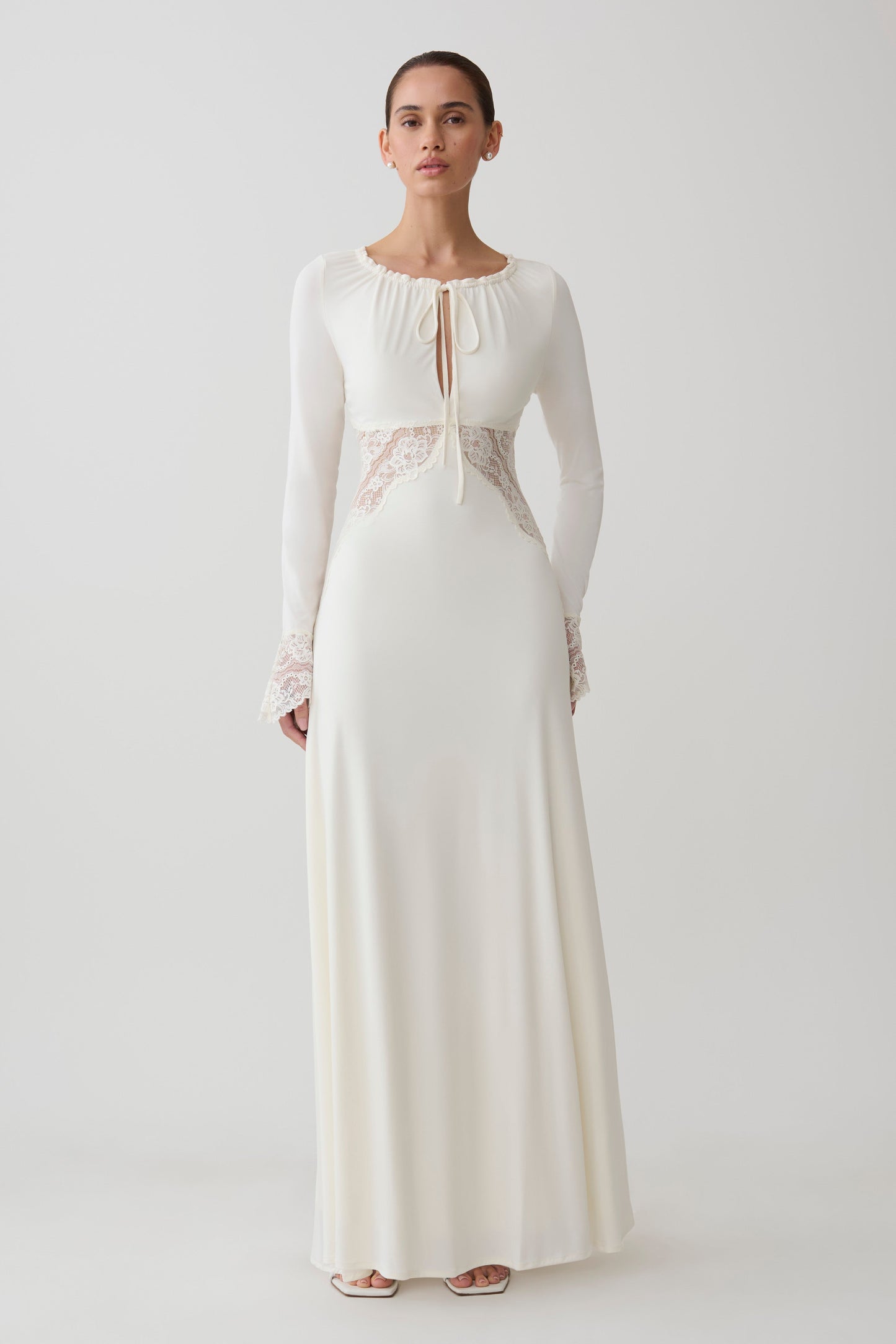 Woman wearing a white lace slinky maxi dress.