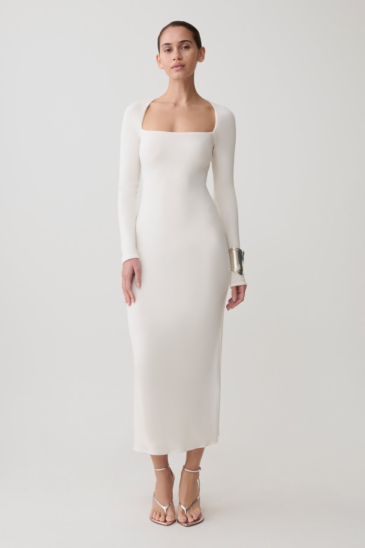 Woman wearing a white long sleeve wool midi dress.