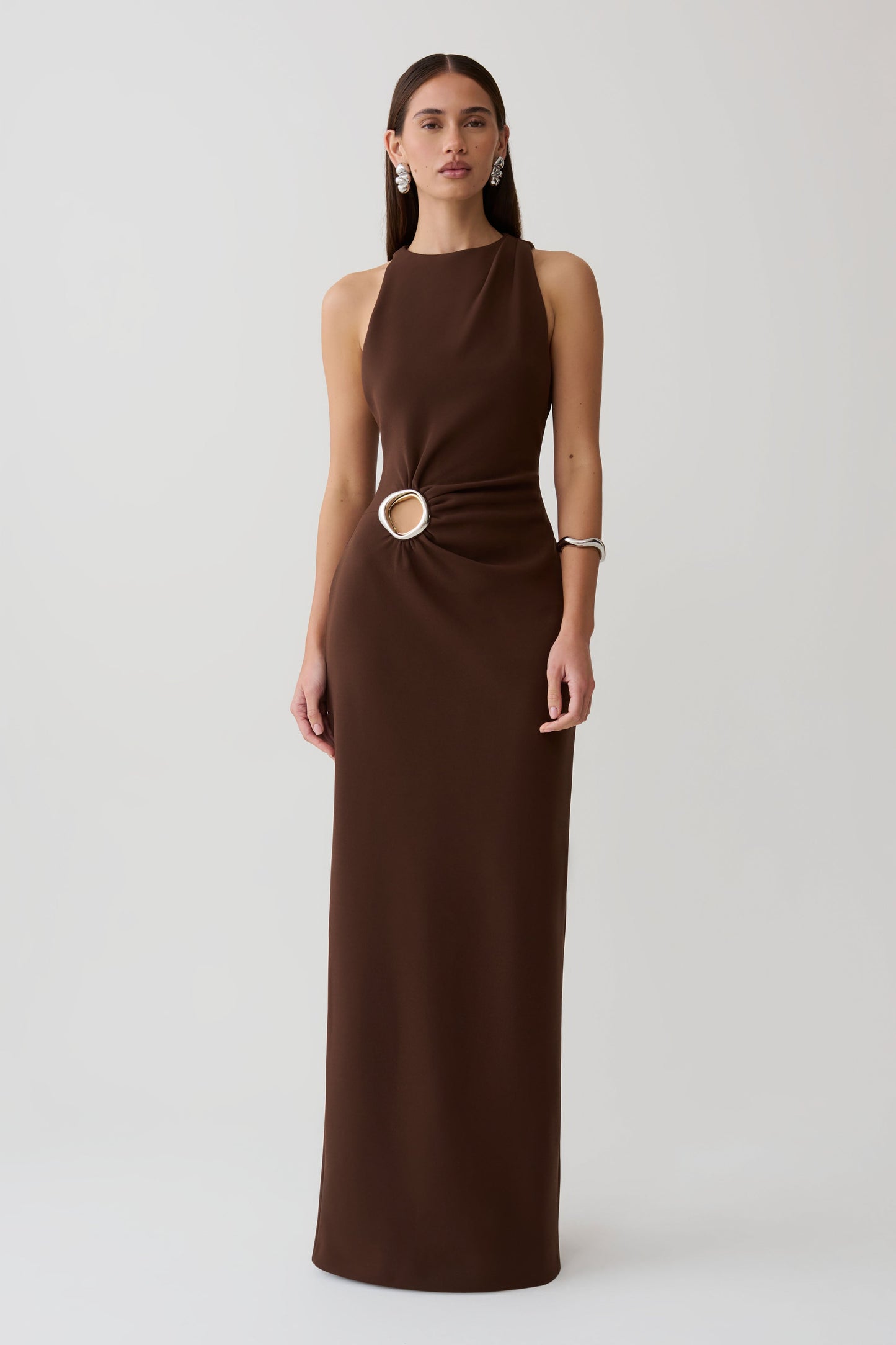 Woman wearing a brown maxi dress with silver hardware.