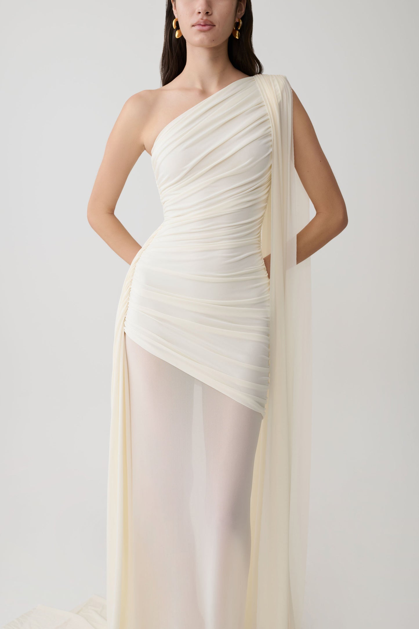 Woman wearing a white one-shoulder maxi dress.