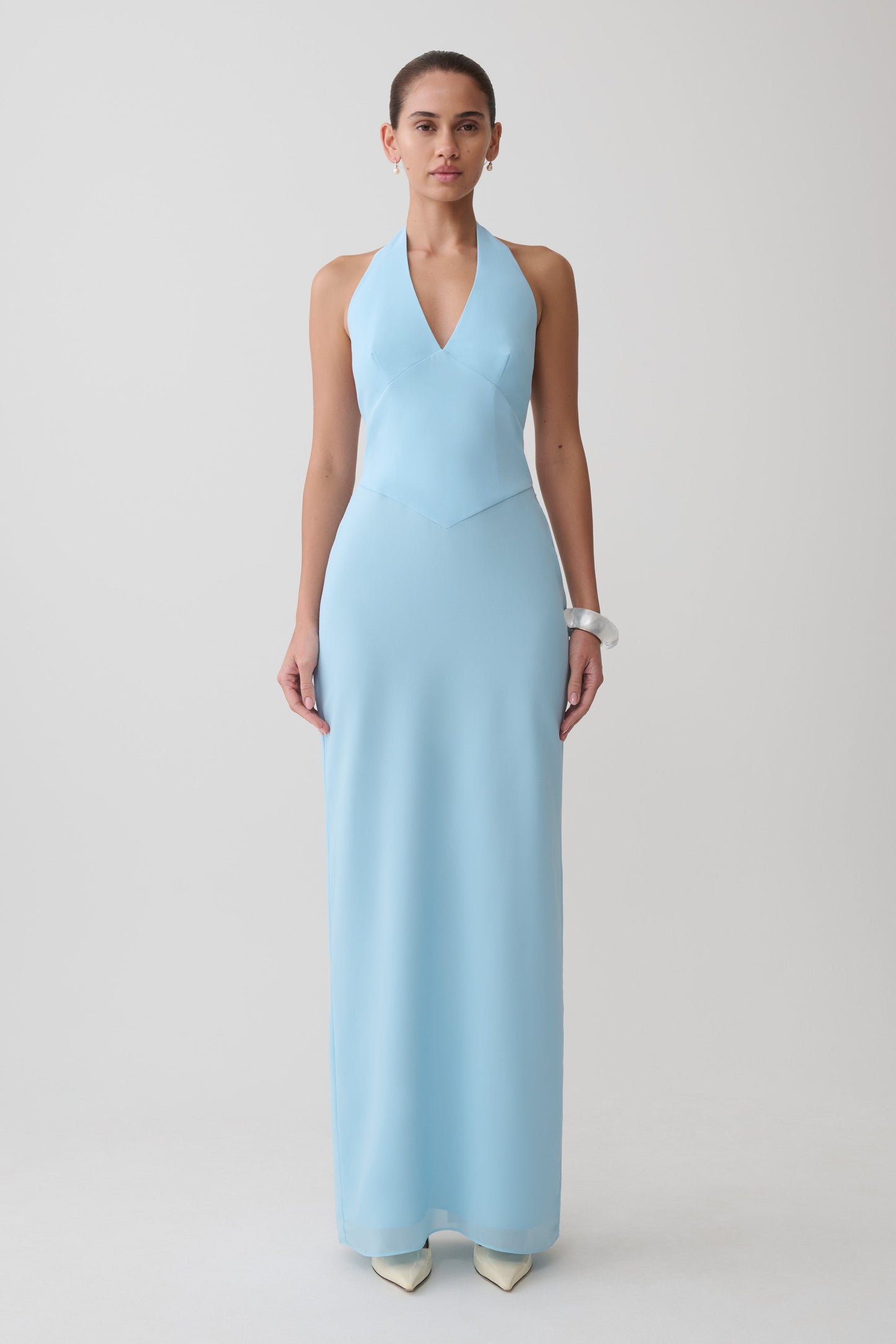 Woman wearing a light blue halter neck maxi dress.
