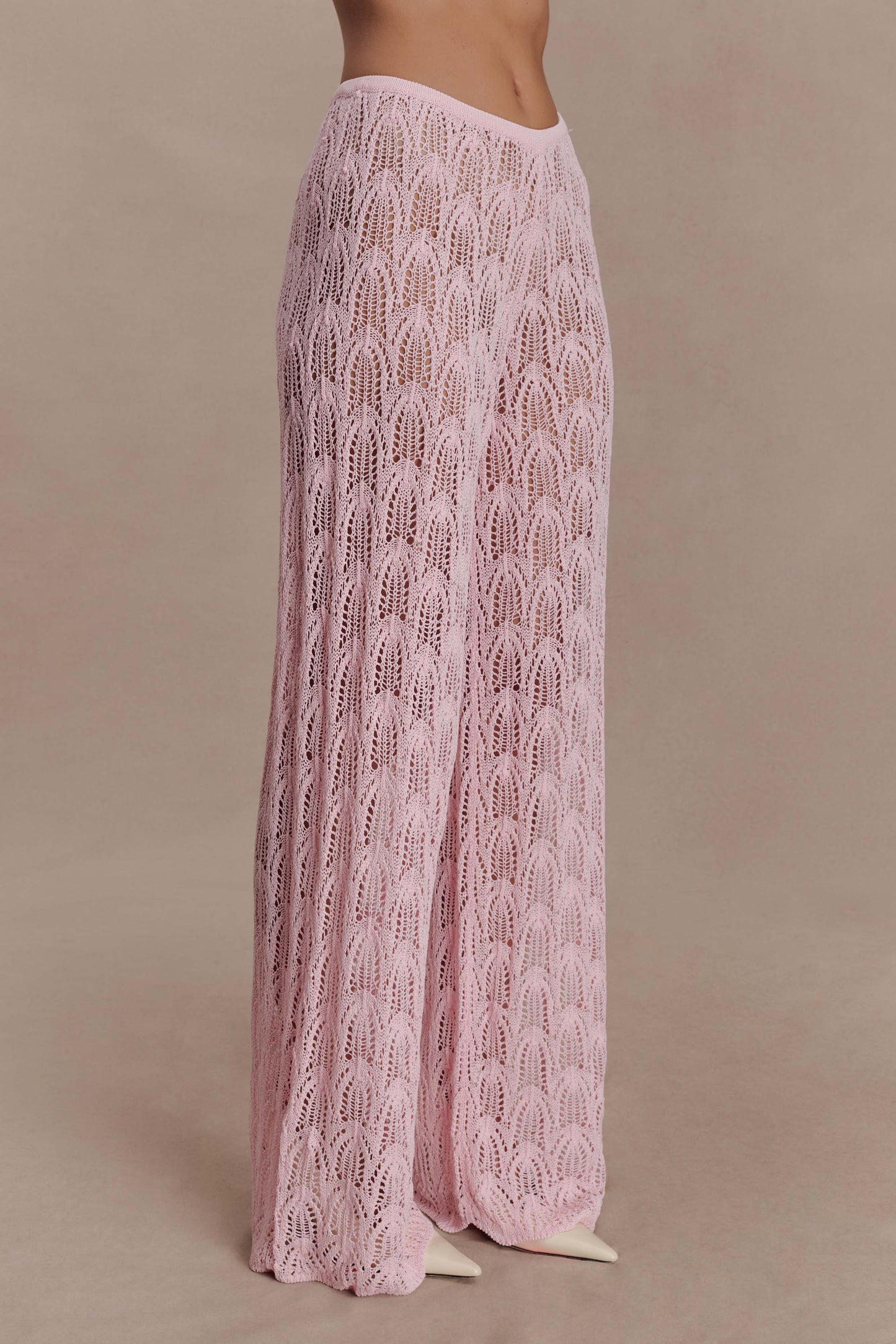 Woman wearing pink crochet pants.