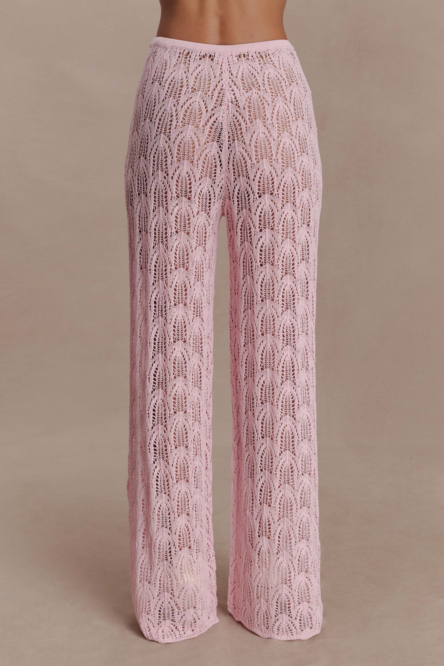 Woman wearing pink crochet pants.