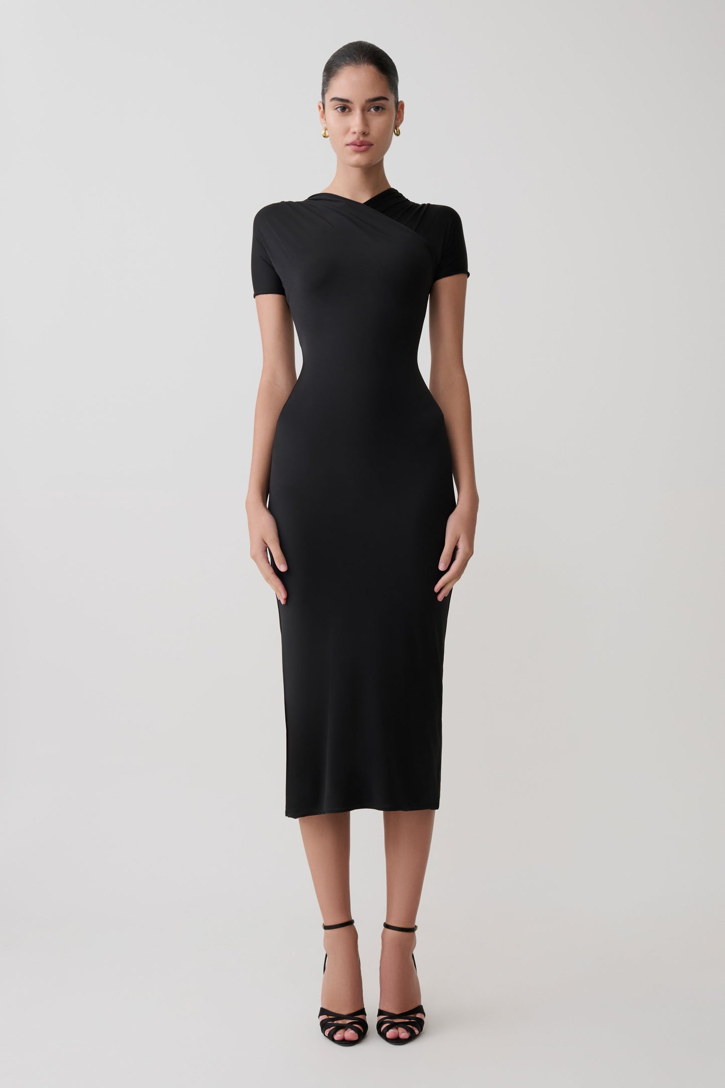 Woman wearing a black dress on a white background.