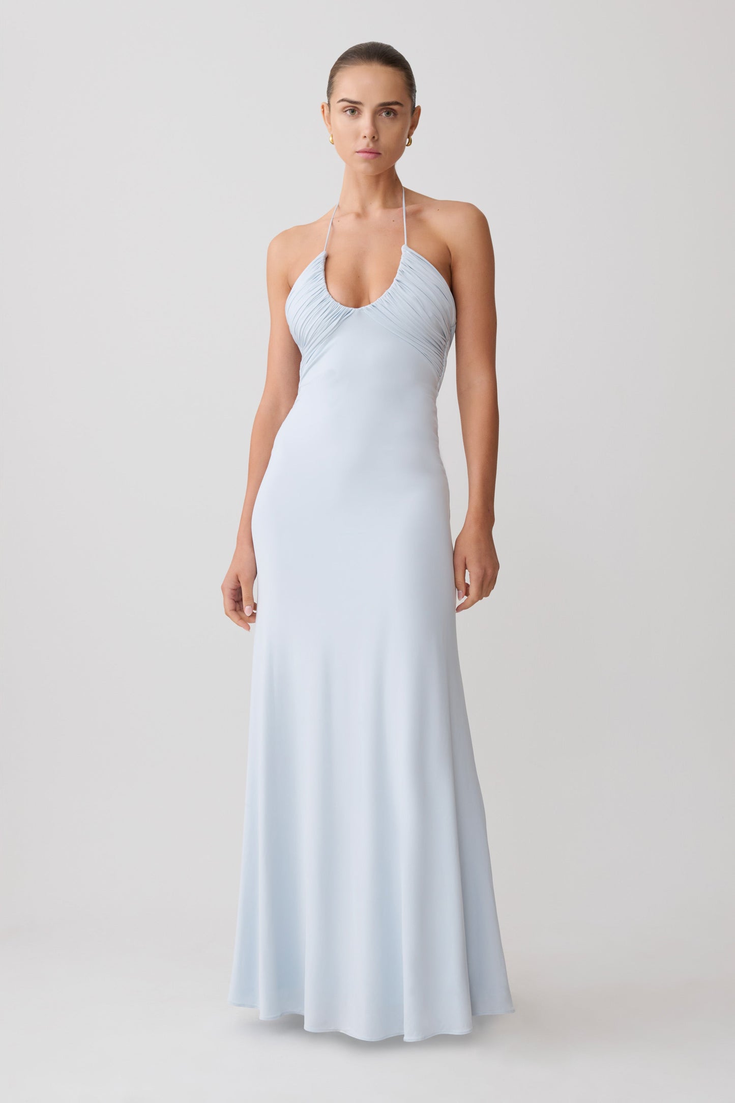 Woman wearing a light blue halter neck maxi dress.