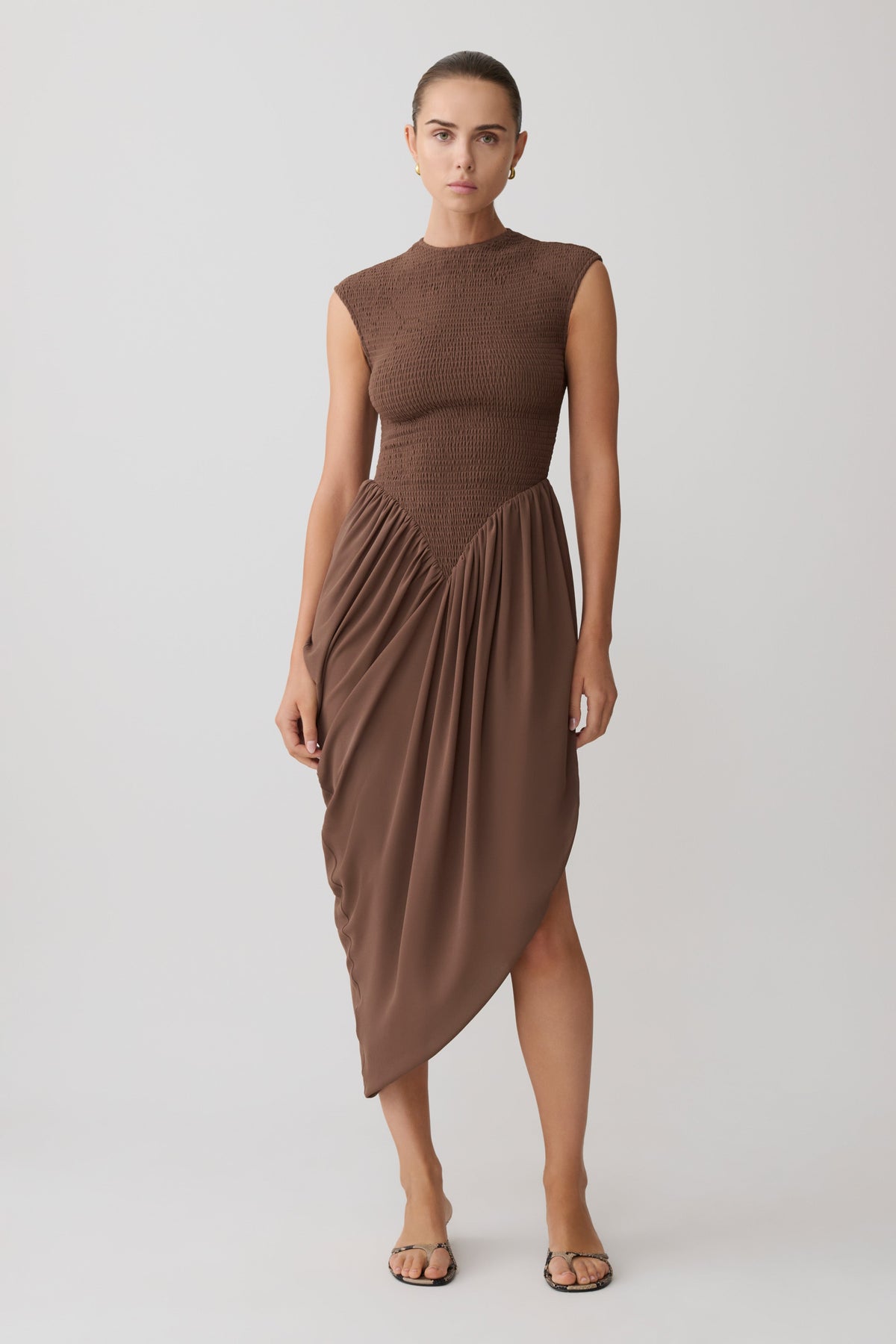 Woman wearing a brown shirred mini sleeveless dress.