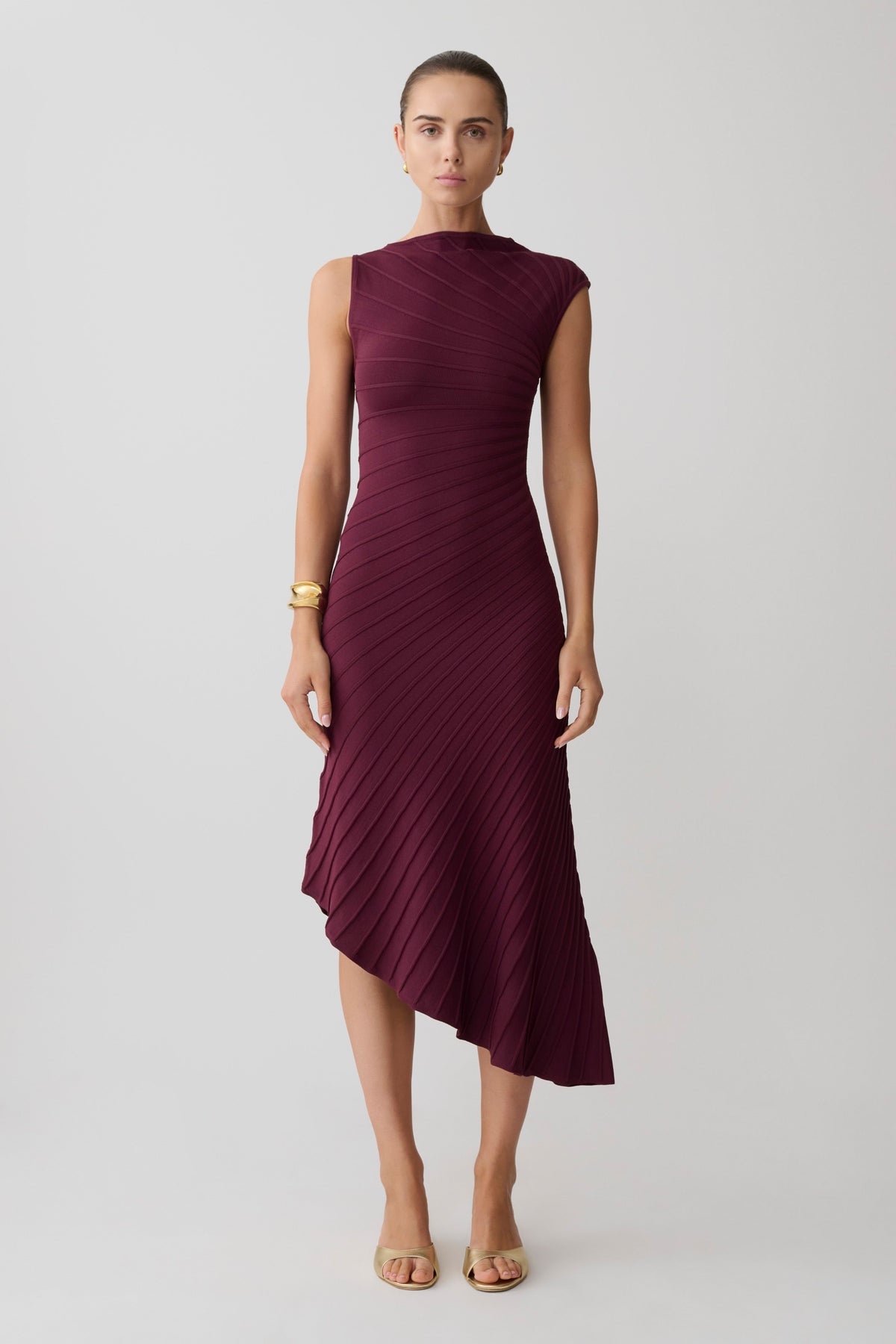 Woman wearing a burgundy pleated maxi dress.