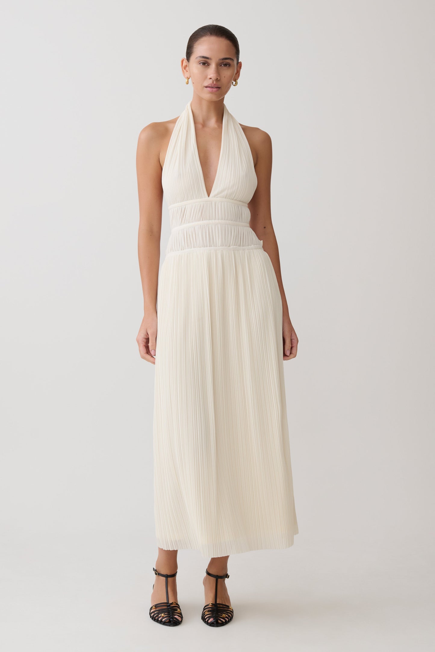 Woman wearing a white halter neck maxi dress.
