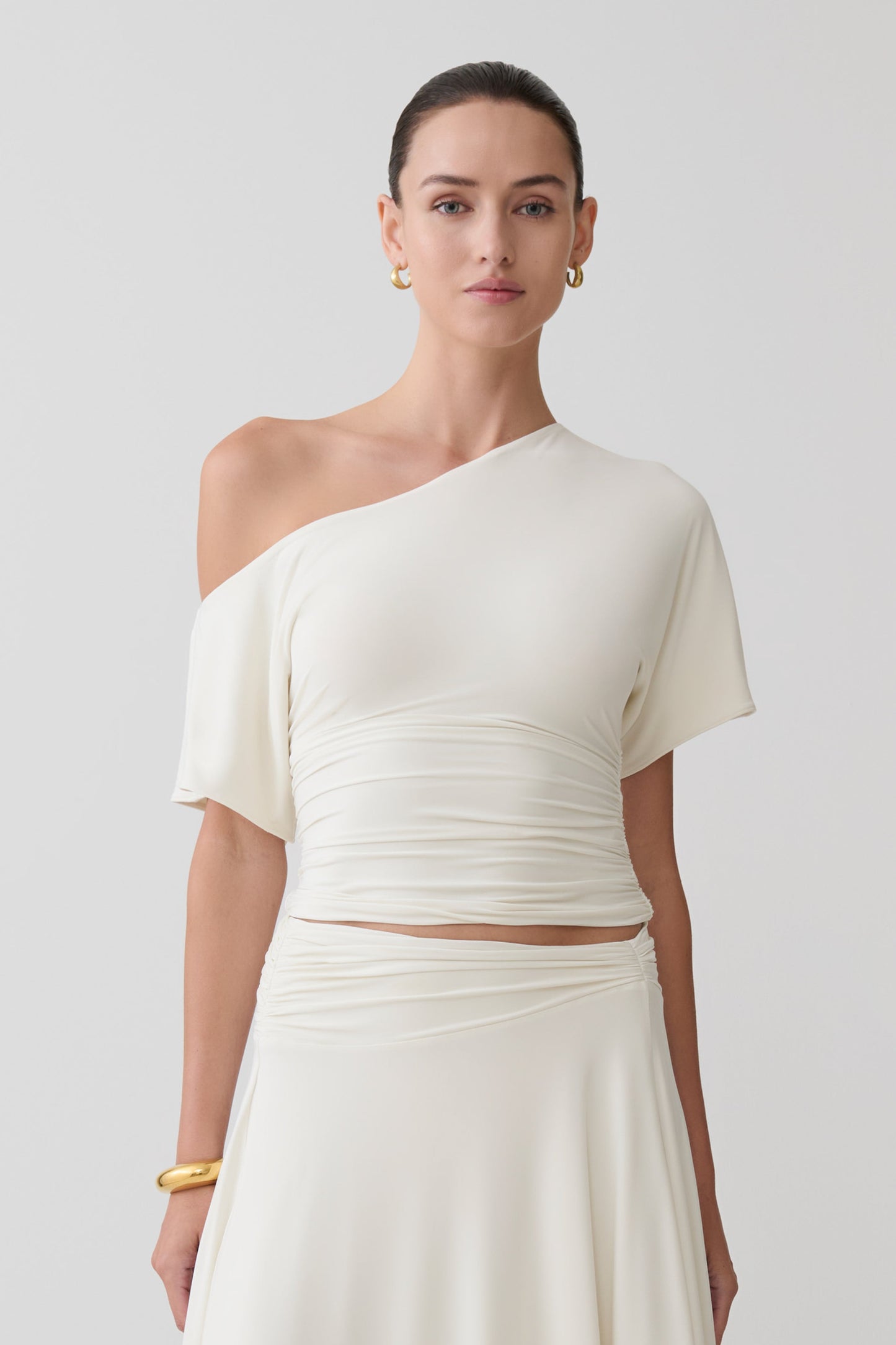 Woman wearing a white off-shoulder top.