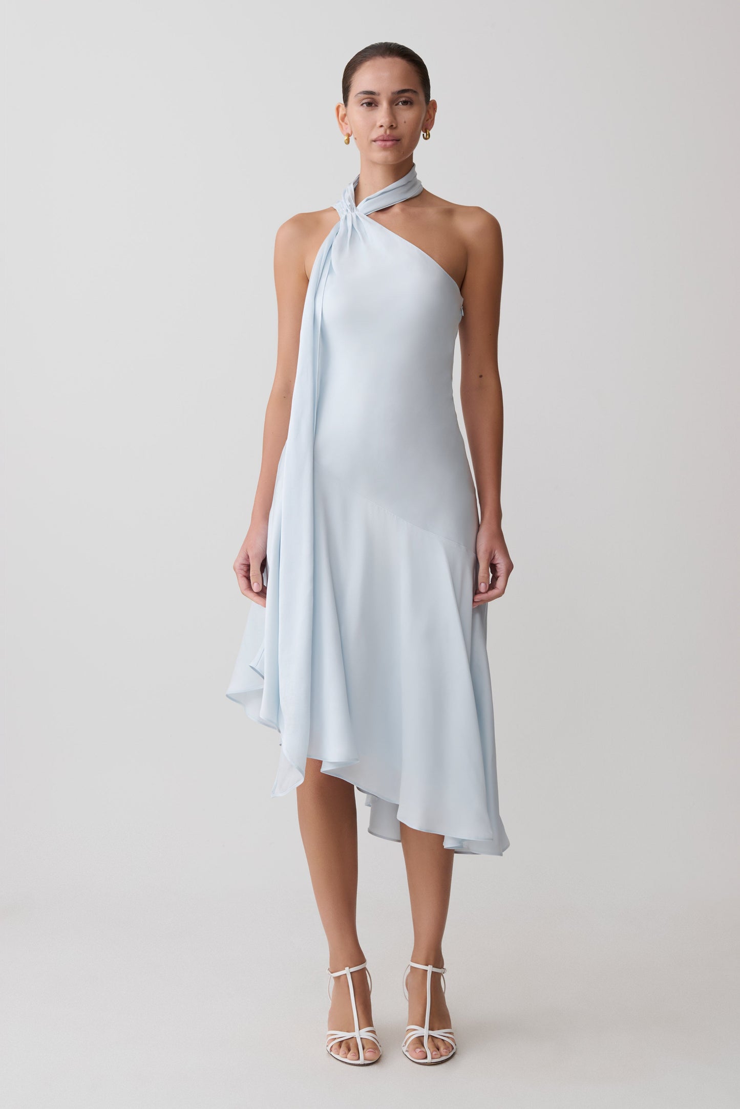 Woman wearing a light blue halter neck dress on a white background