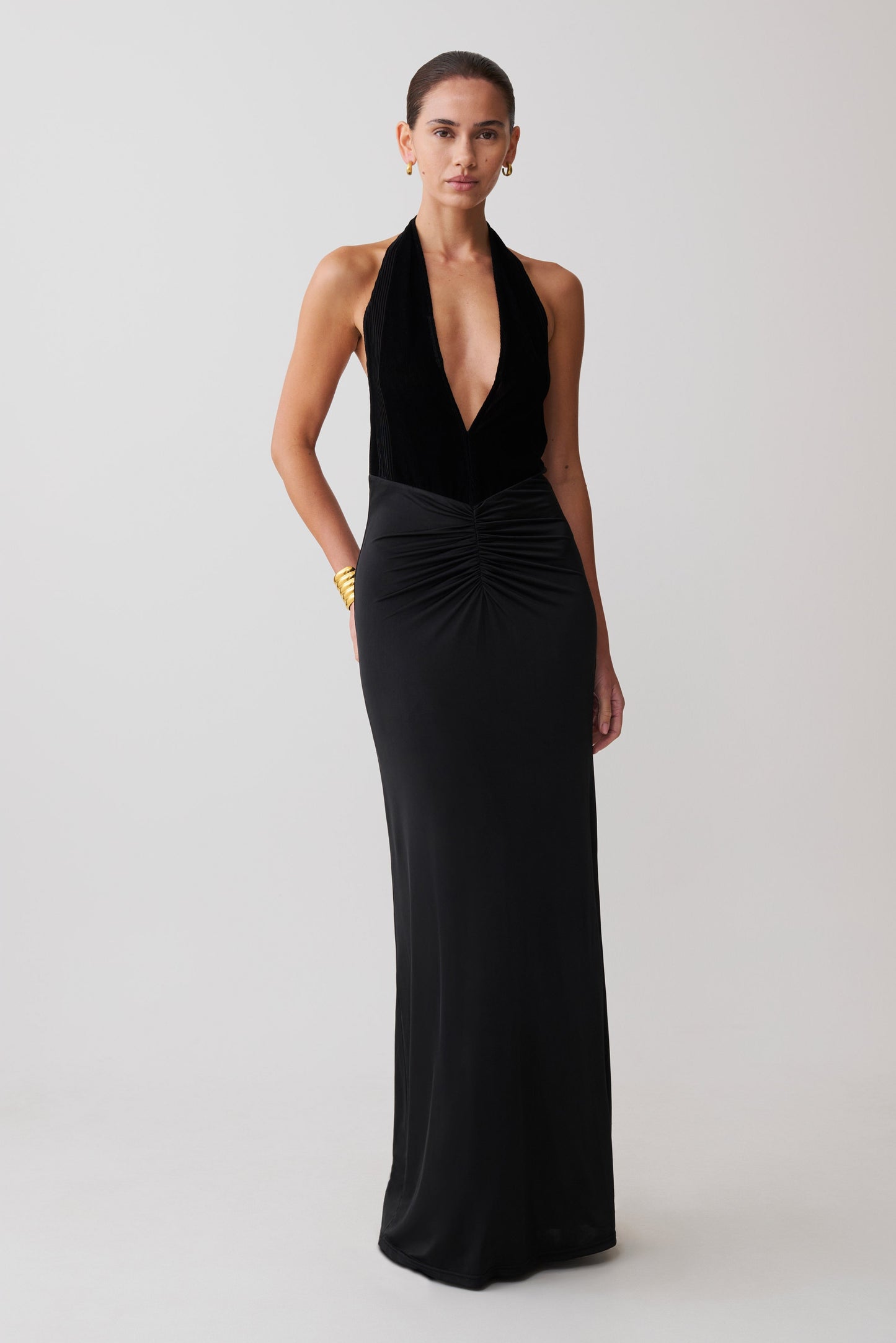 Woman wearing a black halter neck gown on a white background
