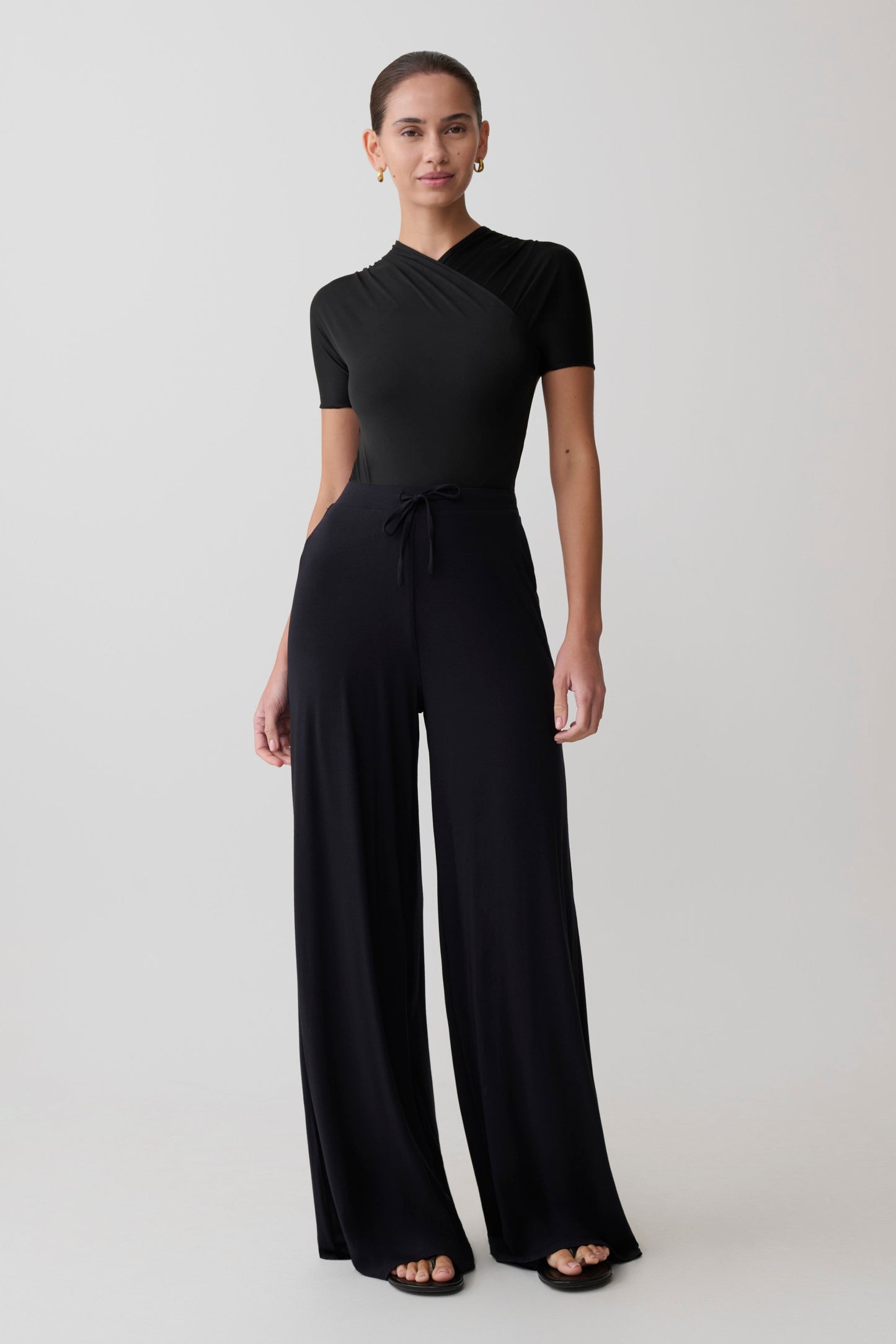 Woman wearing a black jumpsuit on a white background