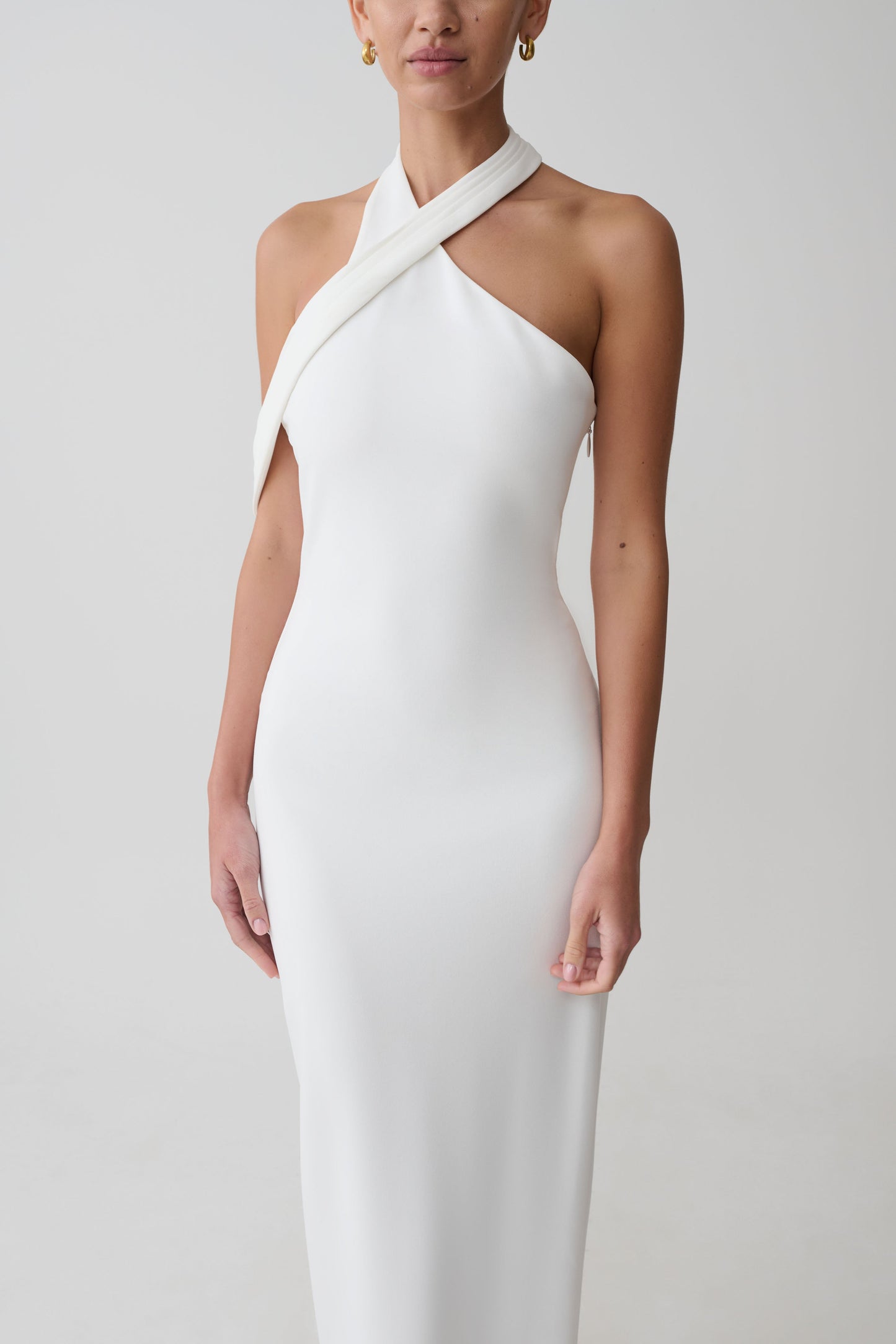 Woman wearing white crossover neck dress.