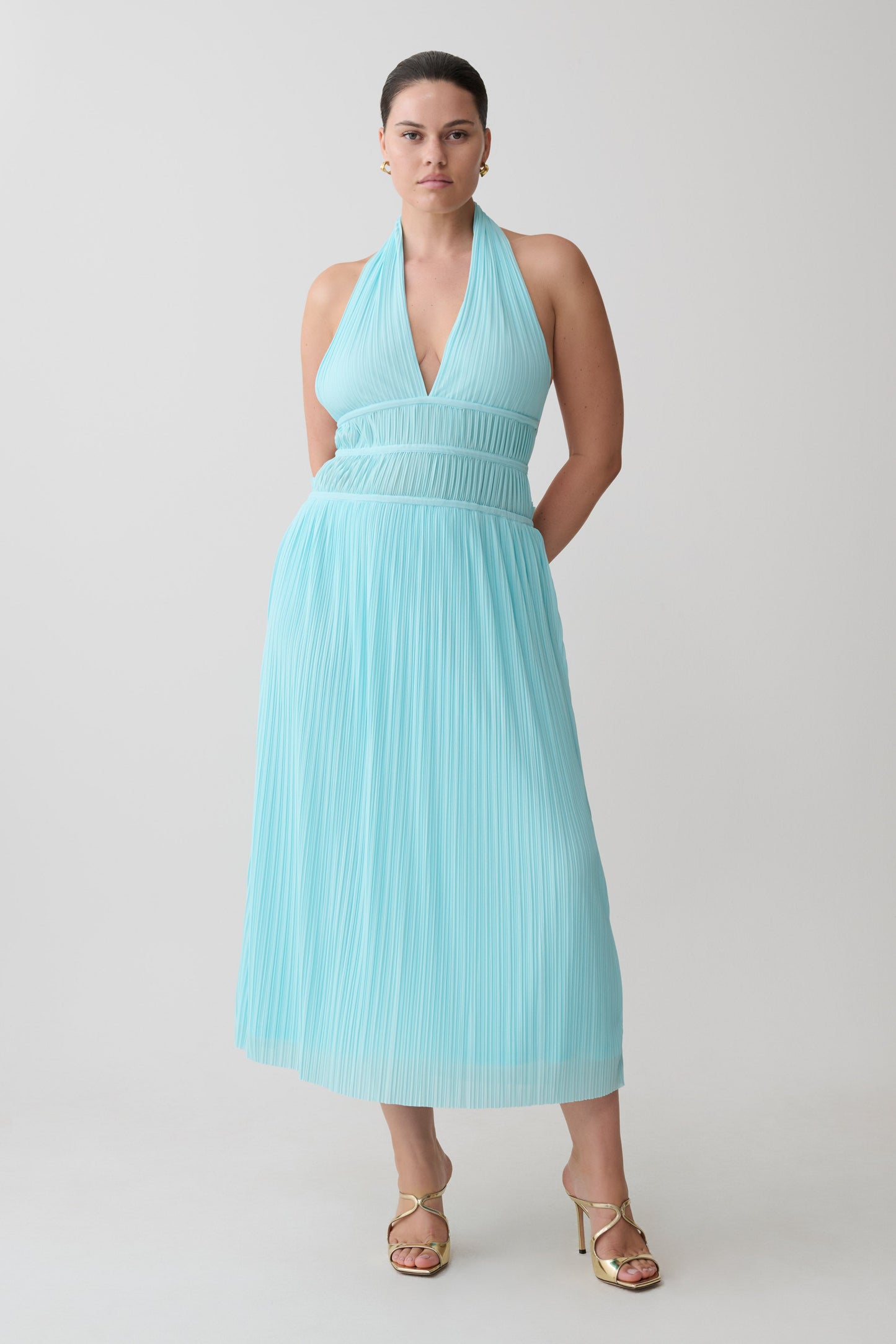 Woman wearing a light blue halter neck maxi dress.