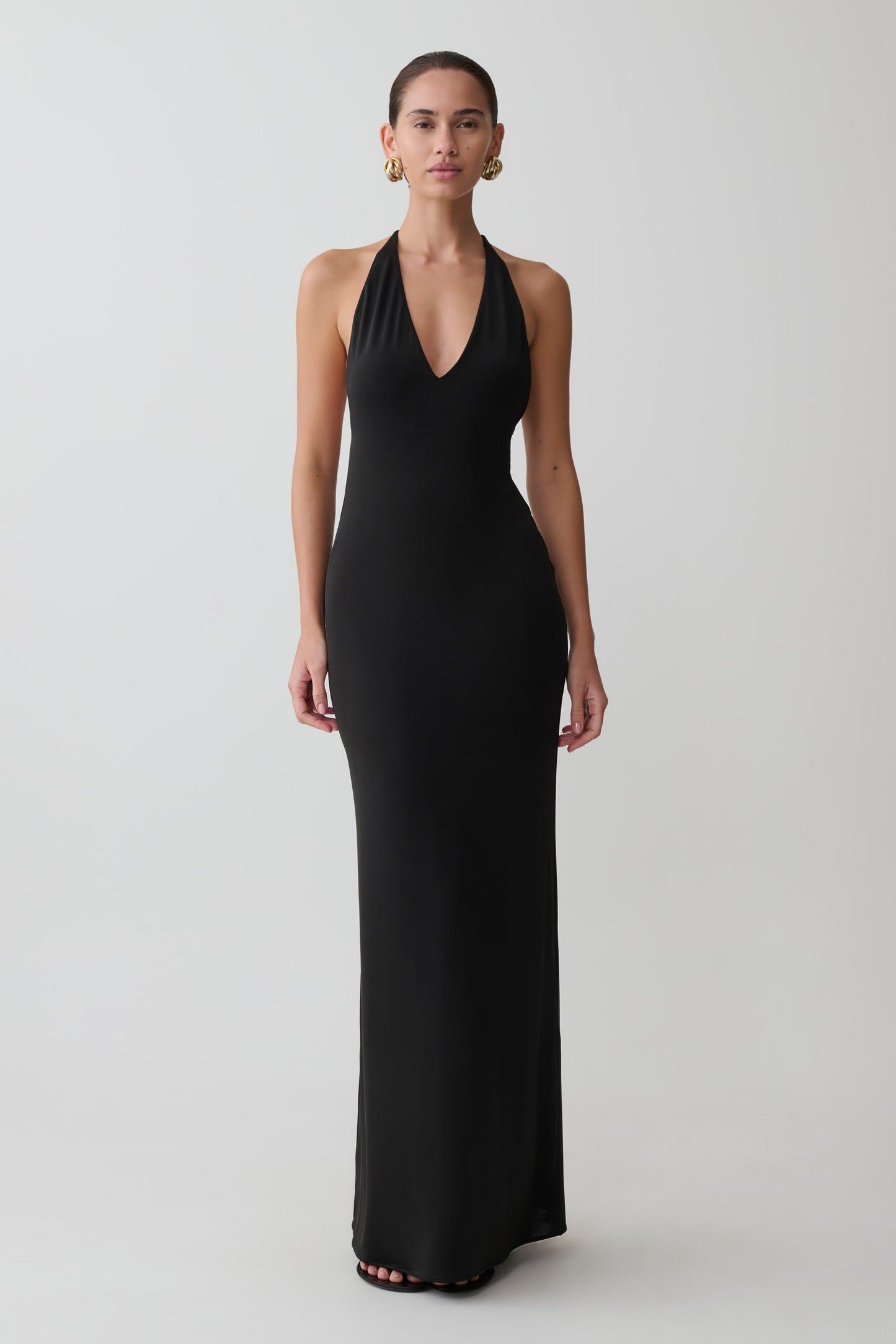 Woman wearing a black halter neck gown on a white background