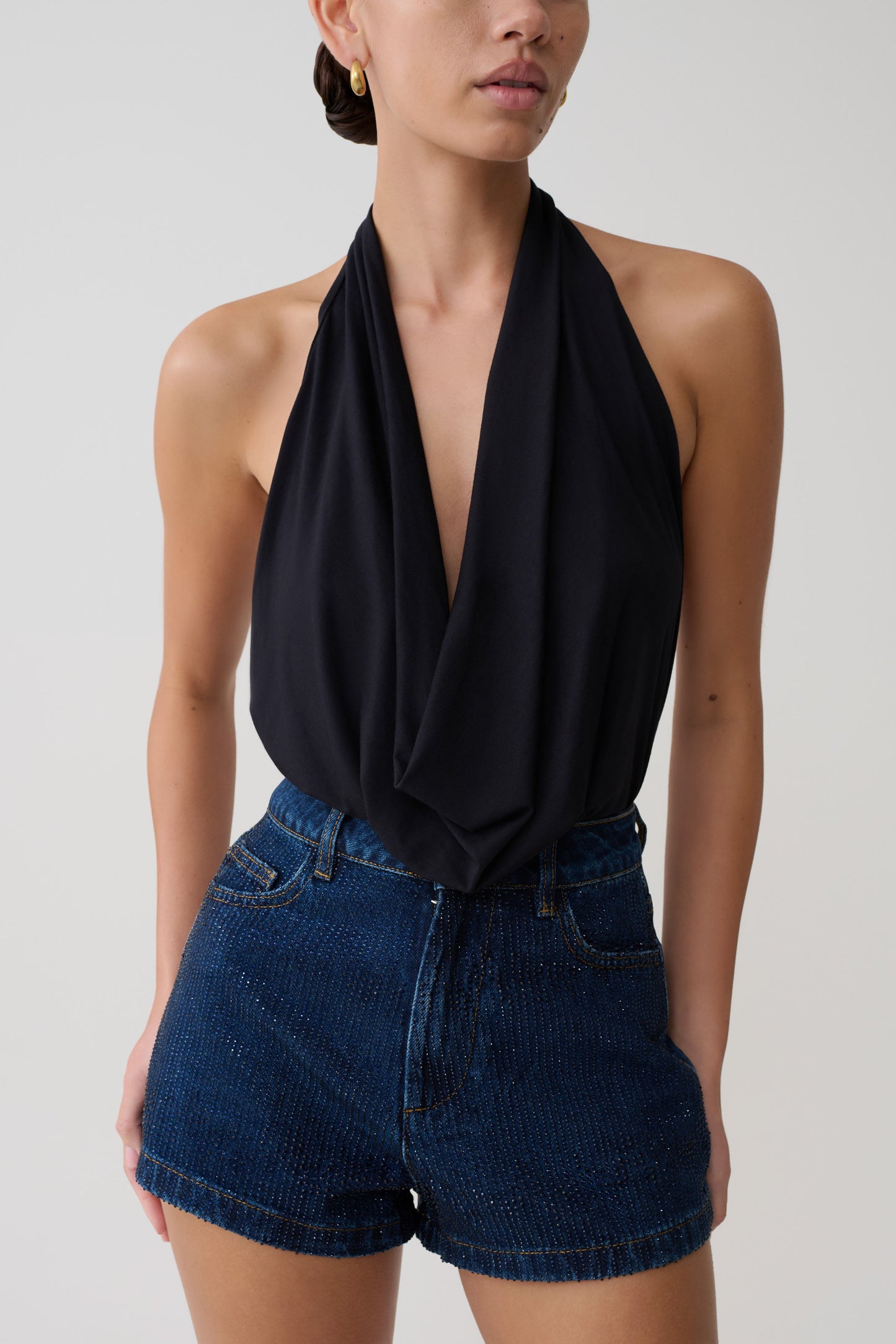 Person in black halterneck plunge top