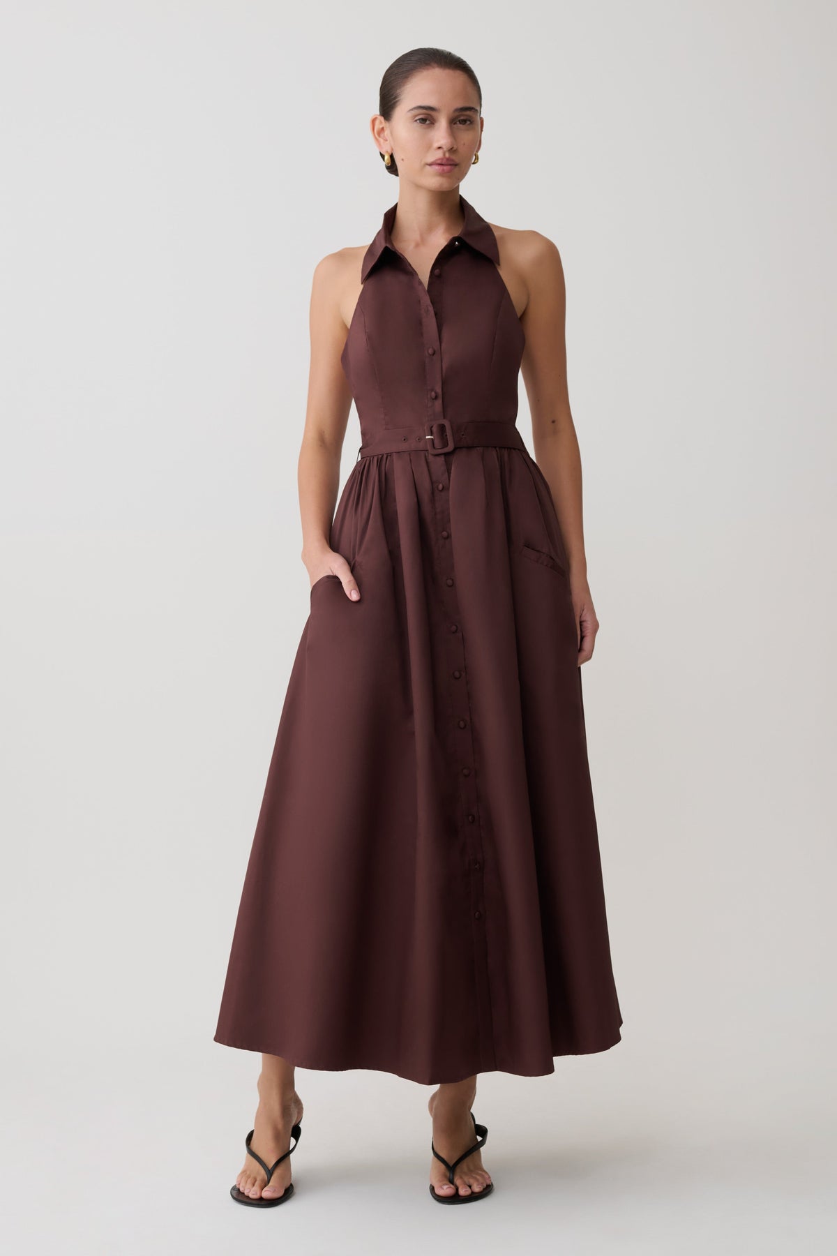 Woman wearing a brown sleeveless dress on a white background