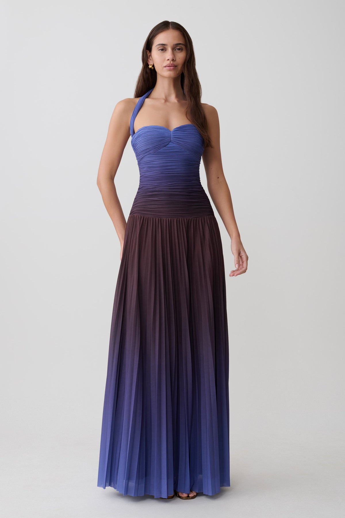 Woman wearing a chocolate and blue ombre pleated halter midi dress.