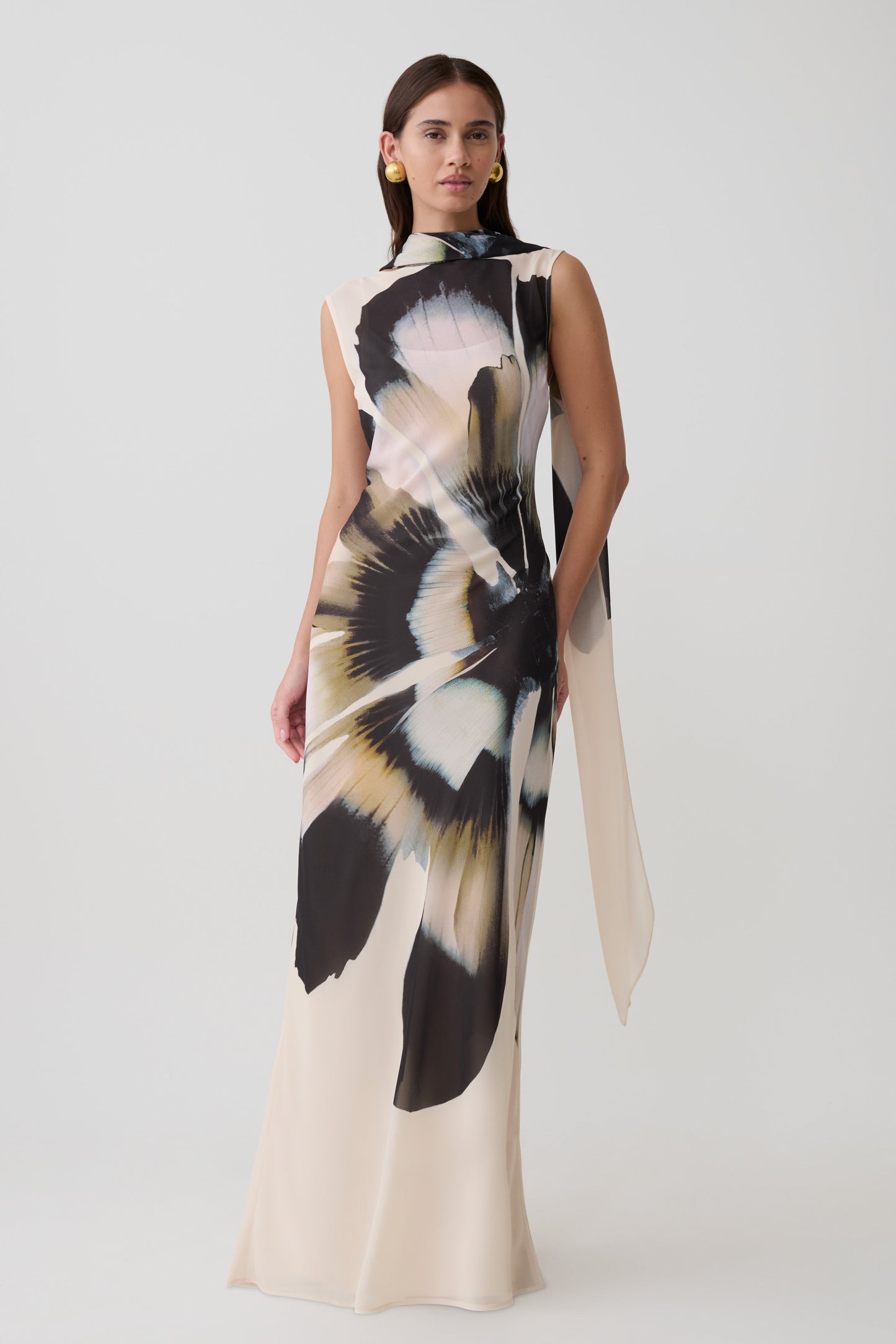 Woman wearing a chiffon maxi dress with ivory print.