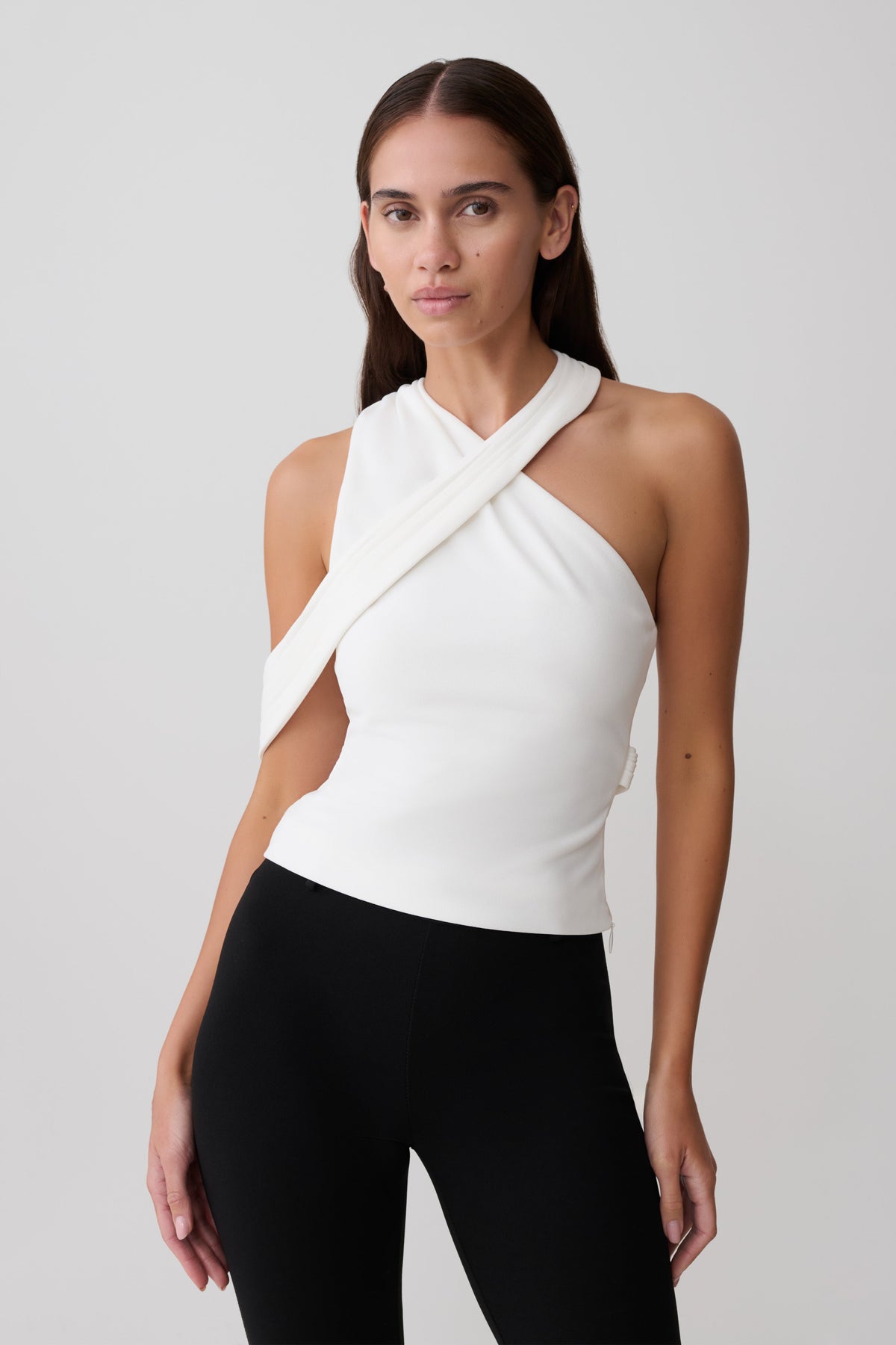 Woman wearing white crossover crepe halter top.