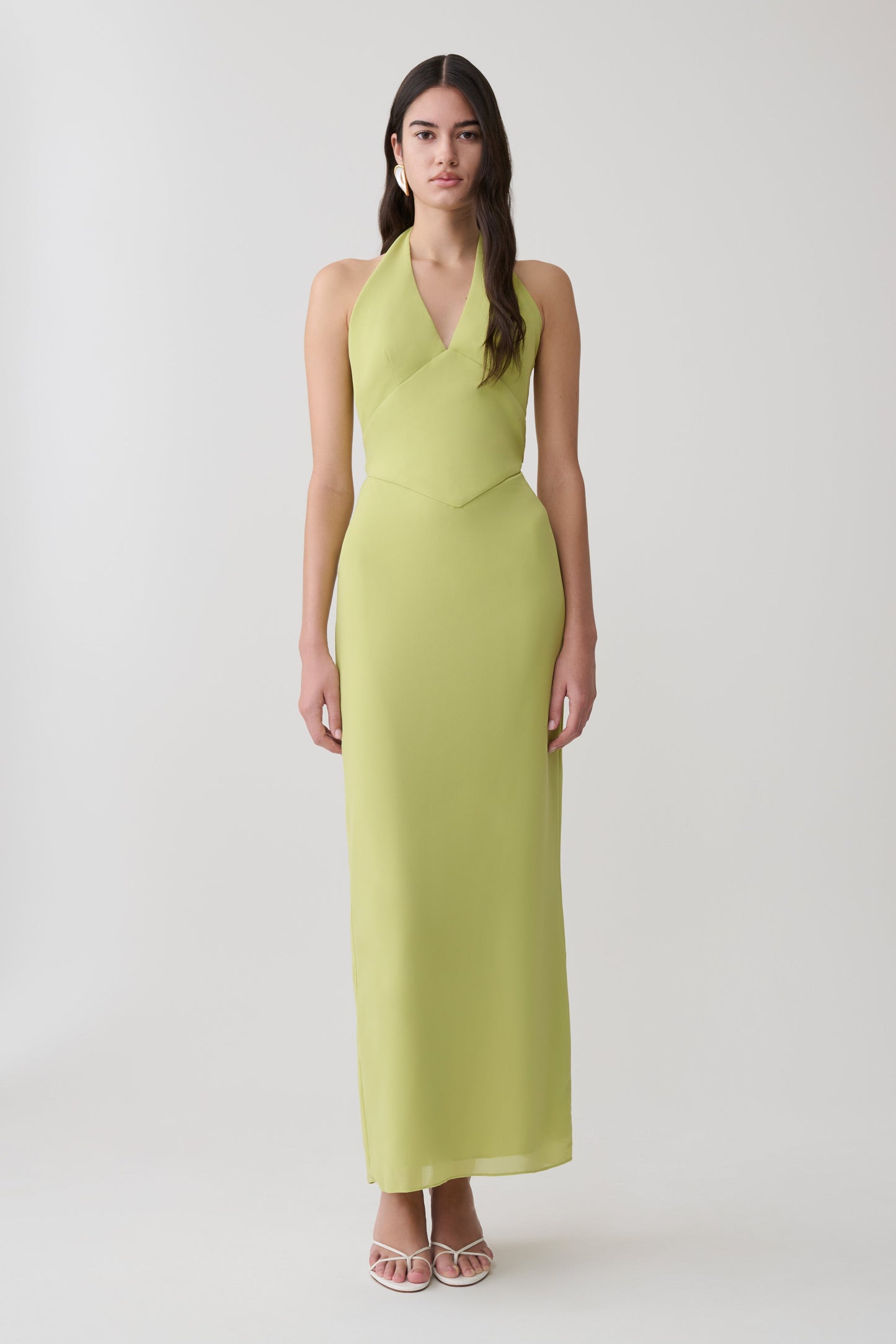 Woman wearing a light green halter maxi dress.