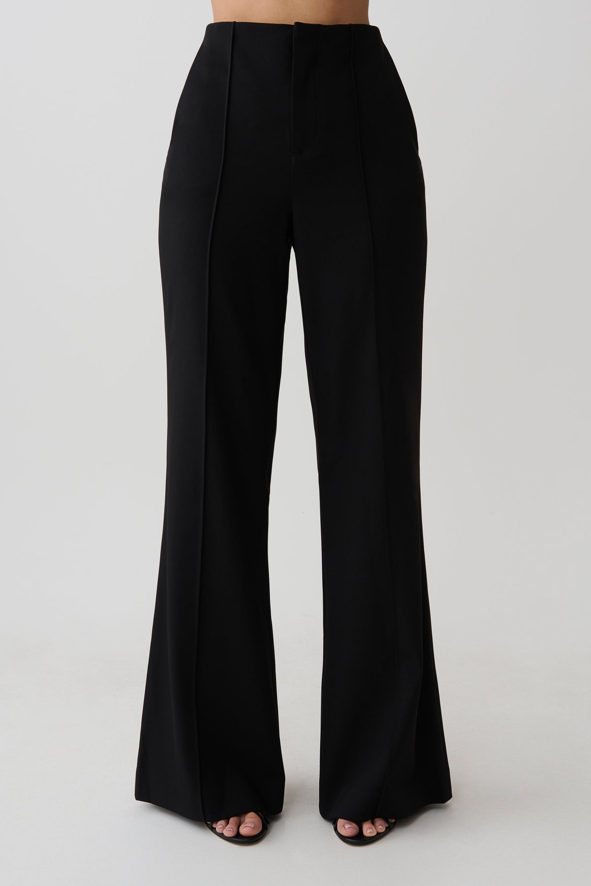 Woman wearing black high waisted suiting pants.