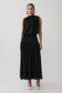 Woman wearing a black sleeveless drop waist gathered midaxi dress.