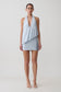 Woman wearing a light blue draped halter mini dress.