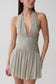 Womn wearing a silver halter pleated mini dress.
