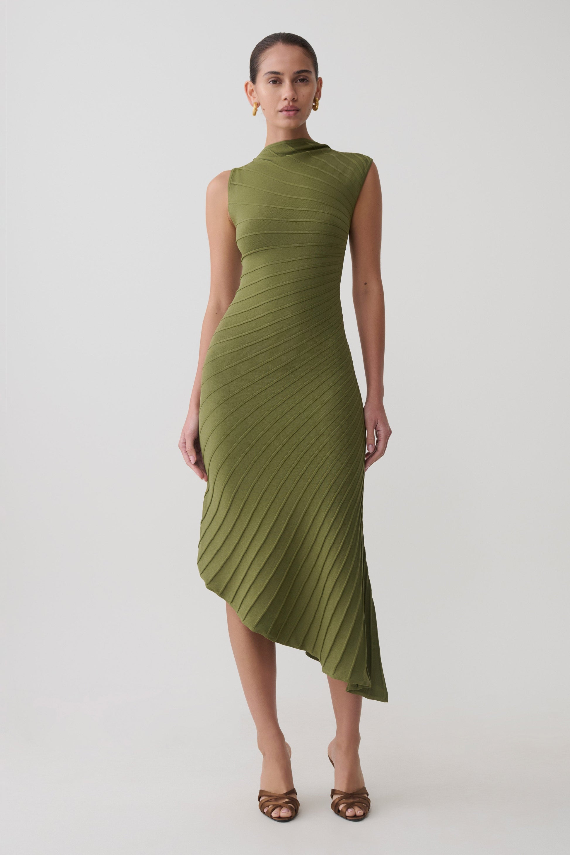 Woman wearing a green pleated knit dress.