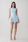 Woman wearing a light blue hankie mini skirt.