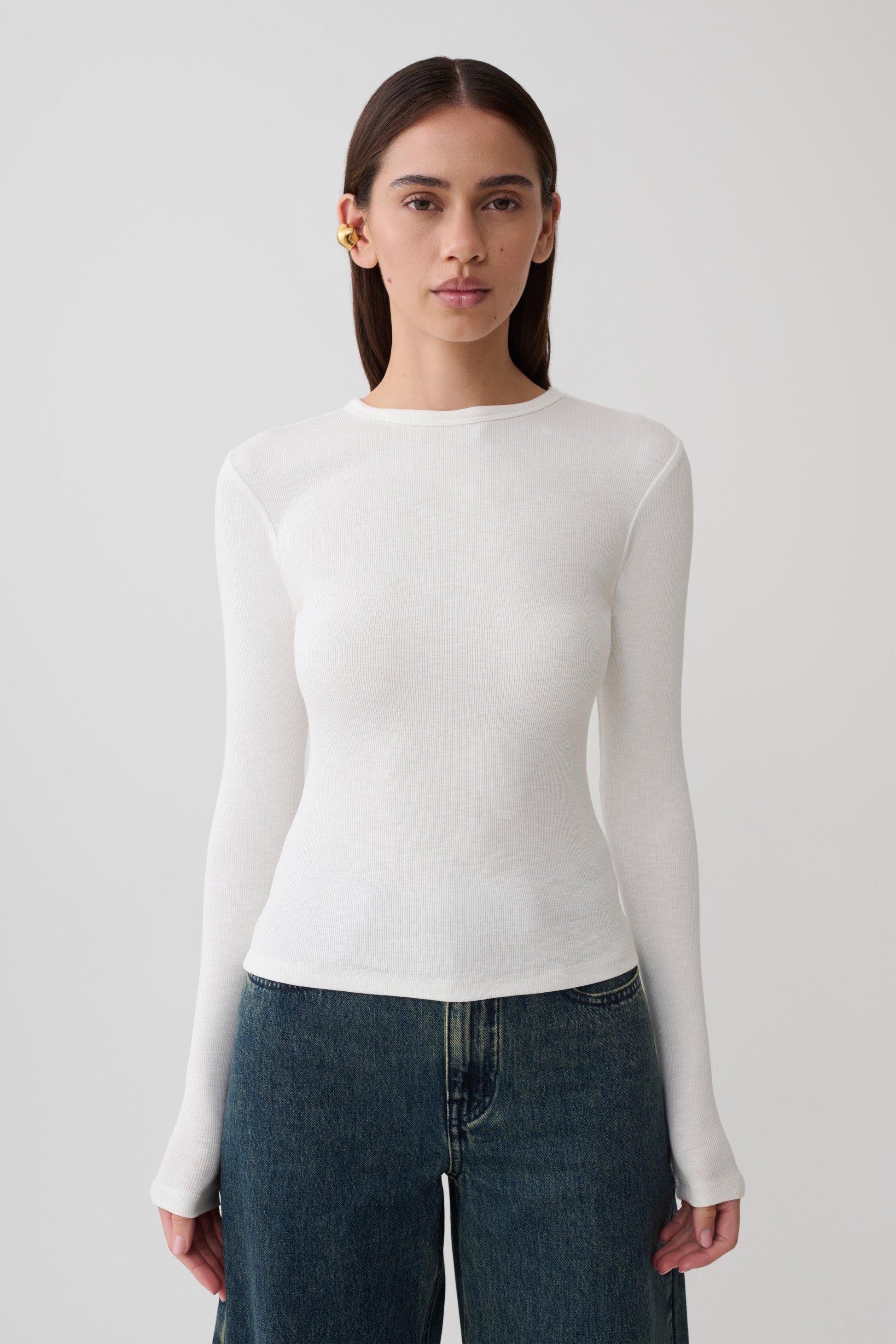 Woman wearing white long sleeve top.