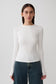 Woman wearing white long sleeve top.