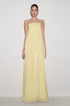 Woman wearing light yellow strapless maxi dress.