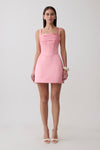 Woman wearing a pink satin corset mini dress.