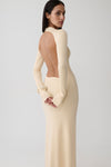 Woman wearing a white long sleeve knit maxi dress.
