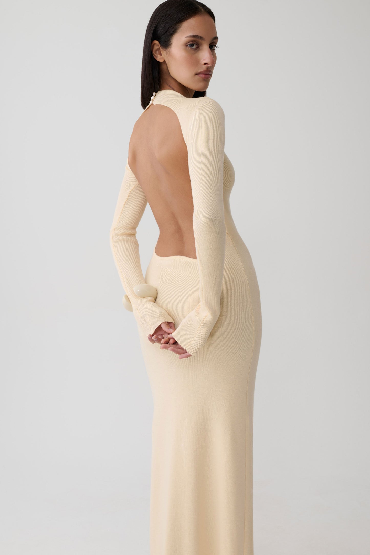Woman wearing a white long sleeve knit maxi dress.