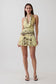 Woman wearing a yellow leopard print mesh halter mini dress.
