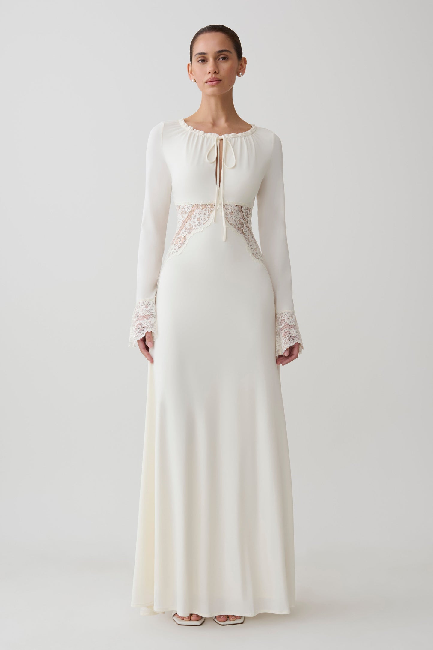 Woman wearing a white lace slinky maxi dress.