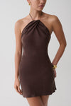 Woman wearing a brown cupro halter mini dress.