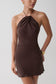 Woman wearing a brown cupro halter mini dress.