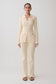 Woman wearing a white ribbed long sleeve longline top with ribbed flared pants.