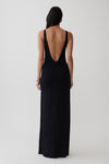 Woman wearing a black backless twist maxi dress.