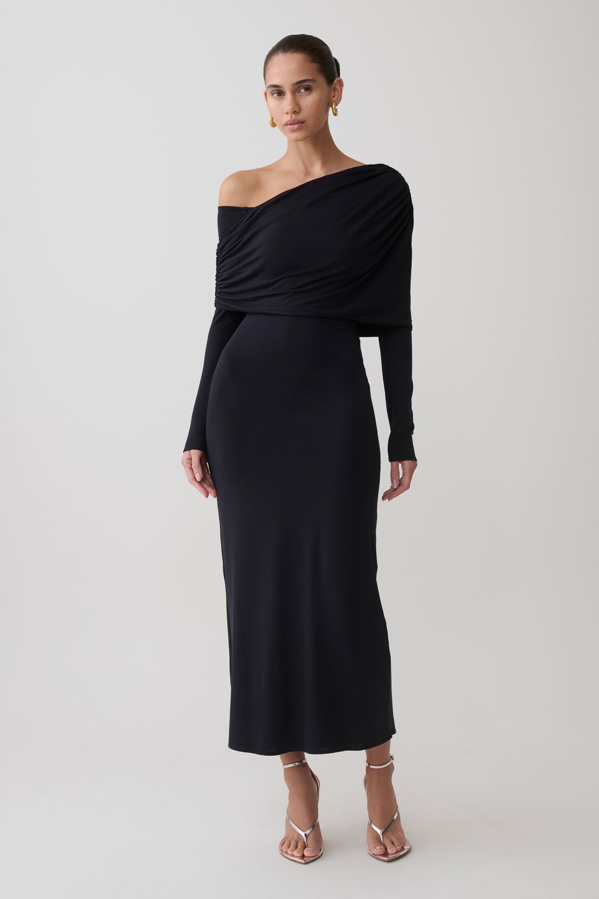 Woman wearing a black modal one shoulder midi dress.