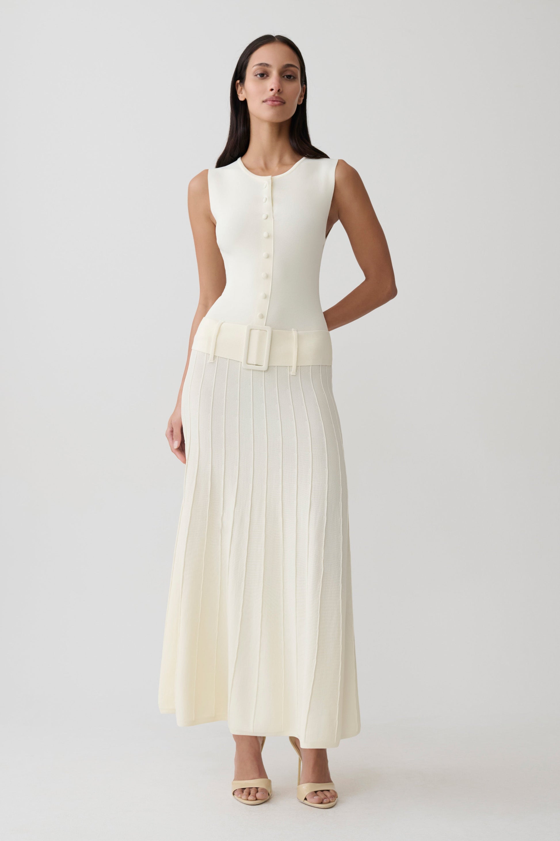 Woman wearing white pleated midi dress.