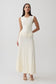 Woman wearing white pleated midi dress.