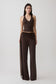 Woman wearing a brown slinky and mesh top with slinky gathered wide leg pants.