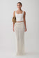 Woman wearing a white sleeveless top and white knit crochet skirt.