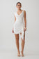 Woman wearing a white cowl drape satin mini dress.