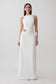 Woman wearing a white maxi dress wiith silver hardware.